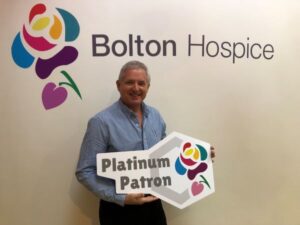 Paul Limb holding the Bolton Hospice Platinum Patron sign